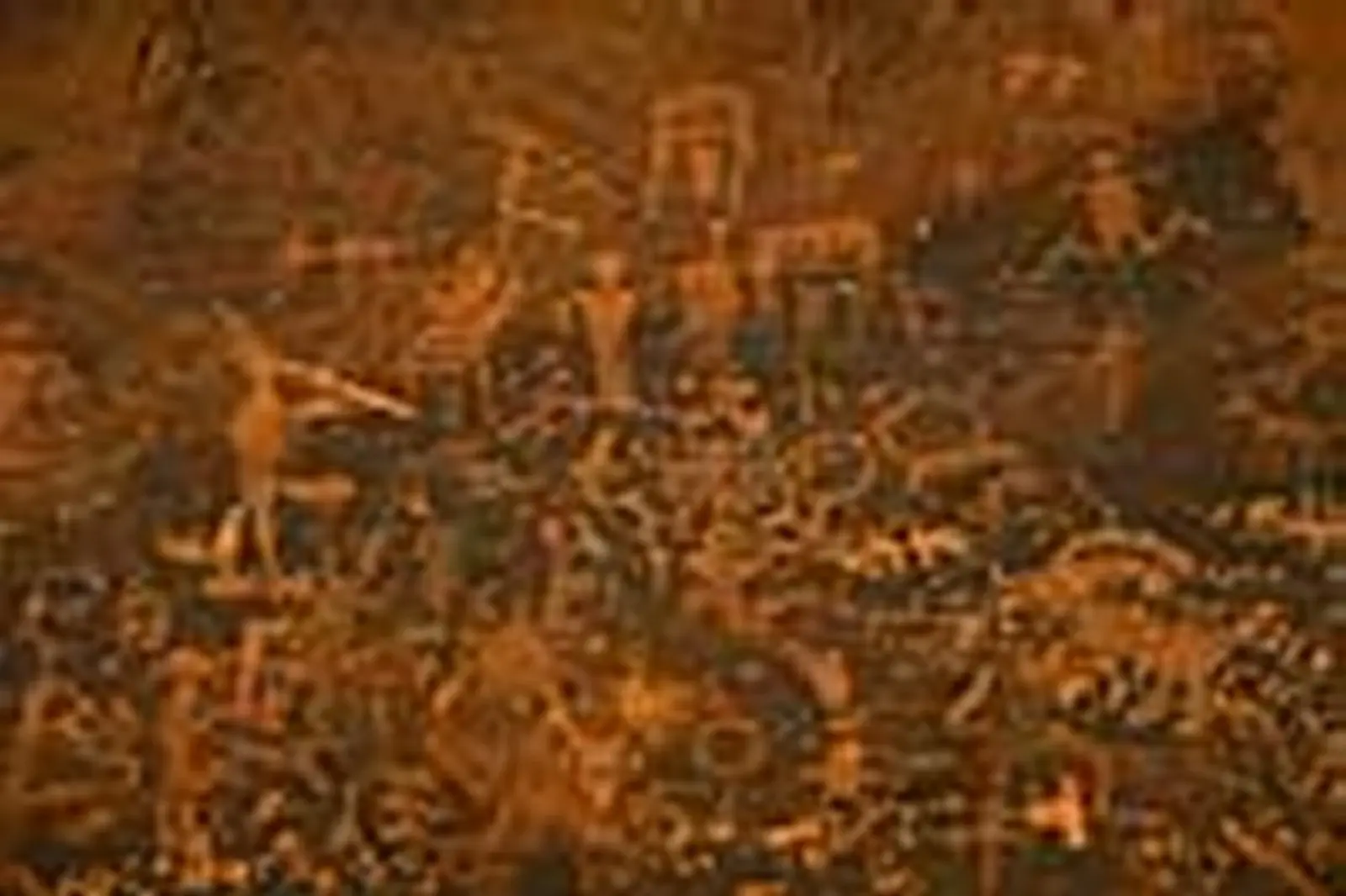 A dense panel of Ancestral Puebloan petroglyphs — figures, spirals, and animals — pecked into a desert-varnished sandstone wall