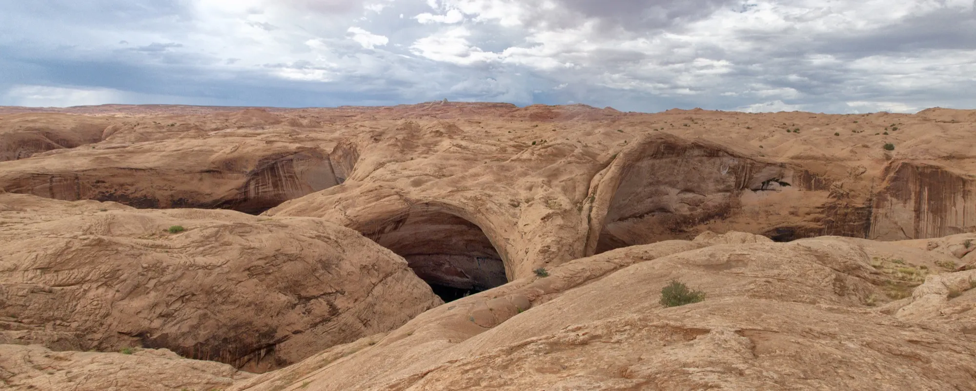 Looking down into the slickrock canyon walls of Coyote Gulch toward Jacob Hamblin Arch