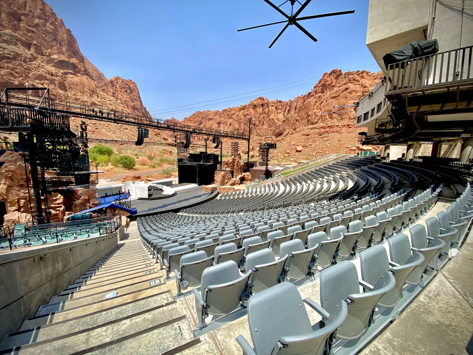 The Tuacahn outdoor amphitheater seating bowl facing the stage with red sandstone cliffs as backdrop